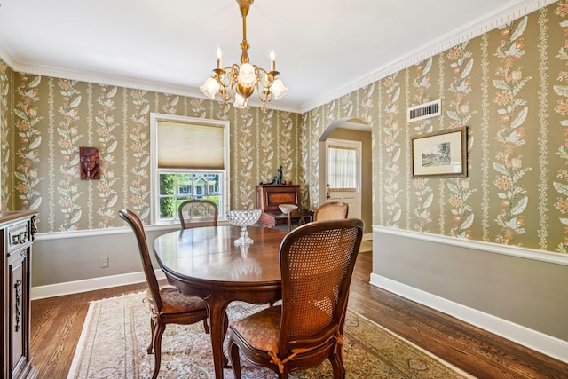 21 Orchard Dr, East Williston, NY 11596 - dining room featuring wood finished floors, arched walkways, a chandelier, plenty of natural light, and ornamental molding