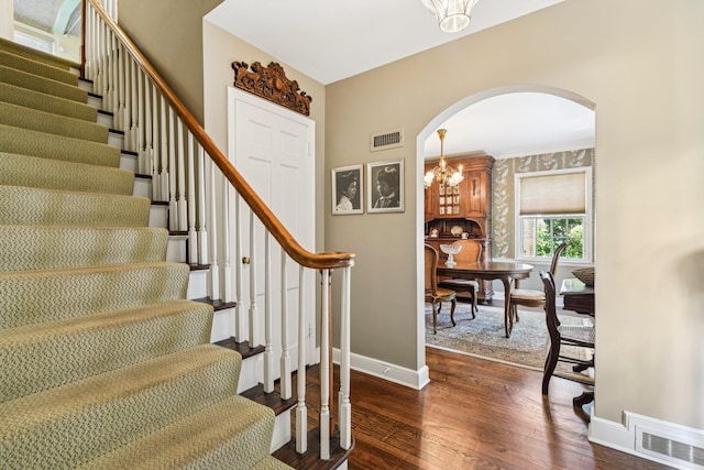 21 Orchard Dr, East Williston, NY 11596 - foyer entrance with arched walkways, stairs, a chandelier, dark wood-type flooring, and wallpapered walls
