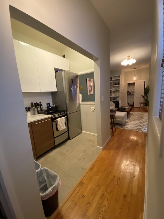 344 E 87th St Unit 3C, New York Manhattan, NY 10128 - kitchen featuring white cabinetry, appliances with stainless steel finishes, light wood-type flooring, light countertops, and modern cabinets