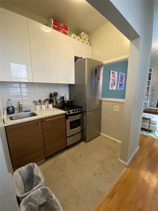 344 E 87th St Unit 3C, New York Manhattan, NY 10128 - kitchen with stainless steel appliances, light countertops, decorative backsplash, modern cabinets, and brown cabinets