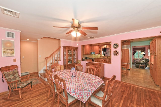 3665 Centerview Ave, Wantagh, NY 11793 - dining room featuring ceiling fan, wood finished floors, stairway, baseboard heating, and ornamental molding