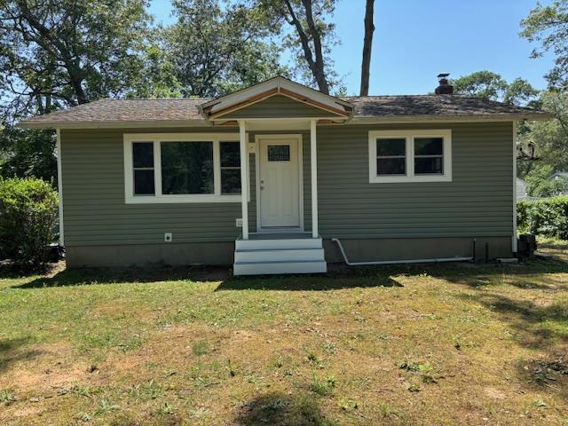 23 Grove St, Riverhead, NY 11901 - bungalow-style house with a front lawn and entry steps