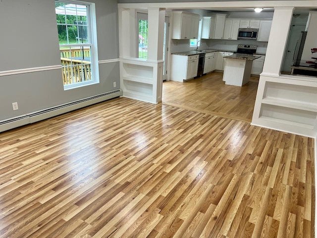 232 Minisink Tpke, Westtown, NY 10998 - kitchen featuring appliances with stainless steel finishes, a baseboard heating unit, light wood-style floors, a center island, and white cabinetry