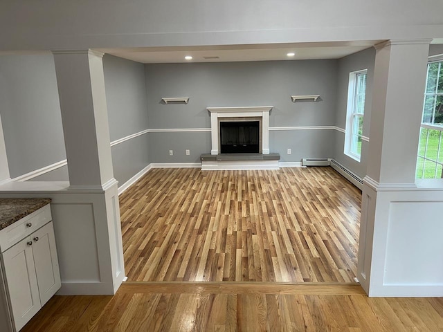 232 Minisink Tpke, Westtown, NY 10998 - unfurnished living room featuring baseboard heating, light wood finished floors, a fireplace with raised hearth, and recessed lighting
