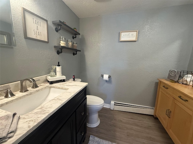 7 Walnut Ct, Goshen, NY 10924 - bathroom featuring a baseboard heating unit, wood finished floors, vanity, a textured ceiling, and a textured wall