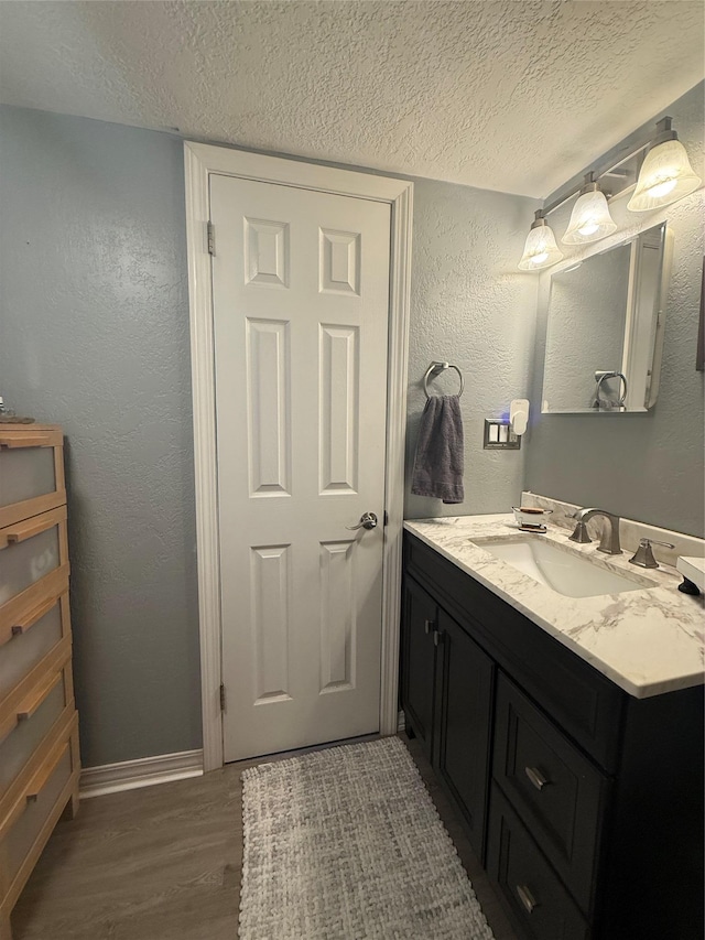 7 Walnut Ct, Goshen, NY 10924 - bathroom featuring a textured ceiling, vanity, wood finished floors, and a textured wall