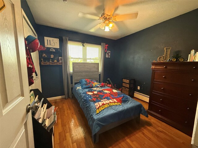 7 Walnut Ct, Goshen, NY 10924 - bedroom featuring a baseboard radiator, wood finished floors, and a ceiling fan