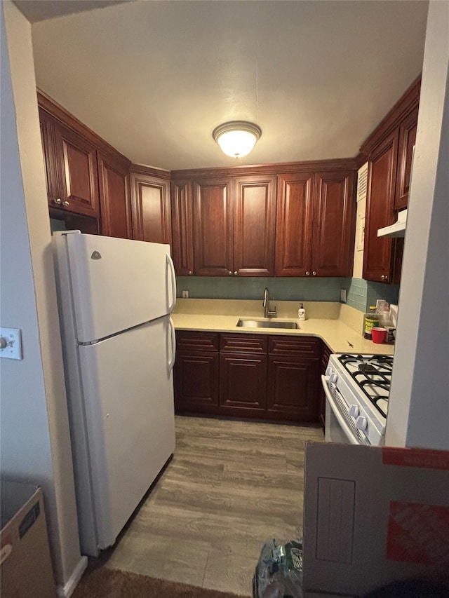 124 Smith St Unit 3B, Freeport, NY 11520 - kitchen with white appliances, light countertops, light wood-style floors, and under cabinet range hood