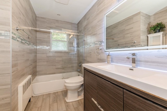 114 Birchwood Park Dr, Syosset, NY 11791 - full bath with radiator heating unit, vanity, bathing tub / shower combination, wood finished floors, and tile walls