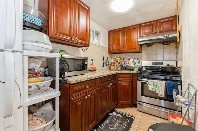 114 Birchwood Park Dr, Syosset, NY 11791 - kitchen with stainless steel appliances, under cabinet range hood, decorative backsplash, and light tile patterned flooring