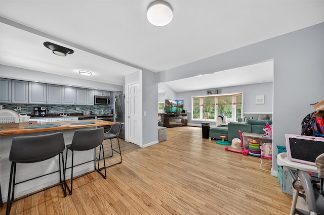 411 Fair Oaks Rd, Middletown, NY 10940 - kitchen with butcher block countertops, open floor plan, appliances with stainless steel finishes, a kitchen bar, and tasteful backsplash