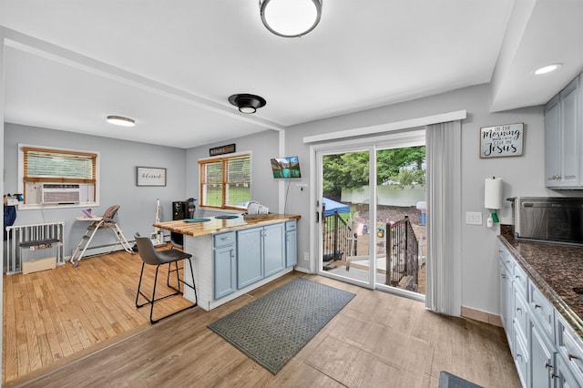 411 Fair Oaks Rd, Middletown, NY 10940 - kitchen with light wood finished floors, a kitchen bar, cooling unit, a baseboard heating unit, and butcher block countertops