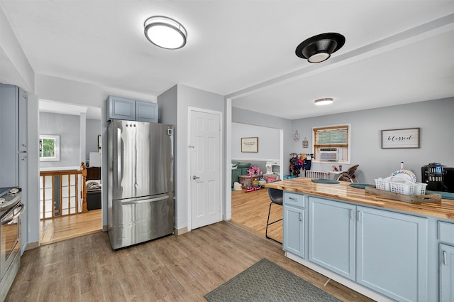 411 Fair Oaks Rd, Middletown, NY 10940 - kitchen with appliances with stainless steel finishes, wooden counters, light wood-type flooring, a breakfast bar area, and blue cabinets