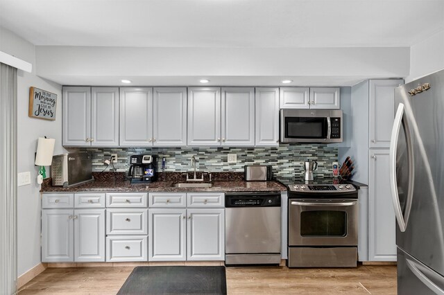 411 Fair Oaks Rd, Middletown, NY 10940 - kitchen with appliances with stainless steel finishes, decorative backsplash, light wood-style floors, dark stone countertops, and recessed lighting