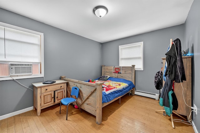 411 Fair Oaks Rd, Middletown, NY 10940 - bedroom featuring a baseboard heating unit, light wood-style floors, and cooling unit