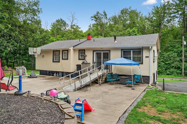 411 Fair Oaks Rd, Middletown, NY 10940 - back of property with a fire pit, a patio, a shingled roof, and view of wooded area