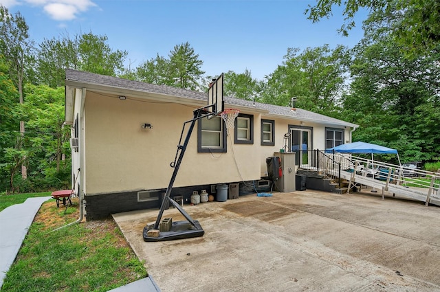 411 Fair Oaks Rd, Middletown, NY 10940 - rear view of house featuring stucco siding, a patio area, and view of wooded area