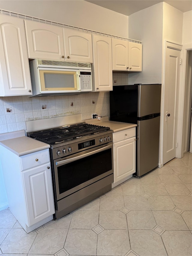 2925 Matthews Ave Unit 5F, Bronx, NY 10467 - kitchen featuring appliances with stainless steel finishes, white cabinetry, backsplash, and light countertops