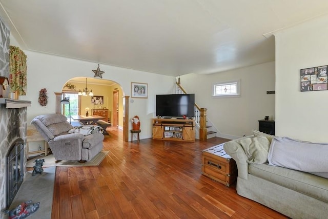 445 Wellington Rd, Mineola, NY 11501 - living room with arched walkways, wood finished floors, a chandelier, and stairs