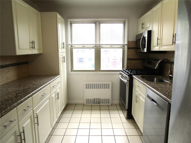 324 Post Ave Apt 8-J, Westbury, NY 11590 - kitchen with radiator heating unit, appliances with stainless steel finishes, backsplash, and white cabinets