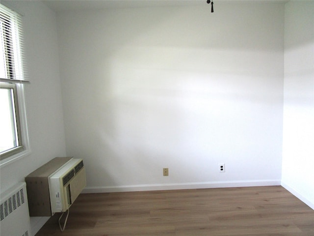 324 Post Ave Apt 8-J, Westbury, NY 11590 - empty room with radiator, wood finished floors, and a wall mounted AC