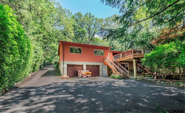 444 Buttermilk Falls Rd, Warwick, NY 10990 - chalet / cabin featuring stairs, asphalt driveway, stucco siding, a garage, and a wooden deck