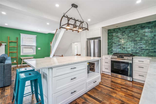 1644 Kenneth Ave, Baldwin, NY 11510 - kitchen featuring appliances with stainless steel finishes, tasteful backsplash, white cabinets, light stone counters, and a kitchen island