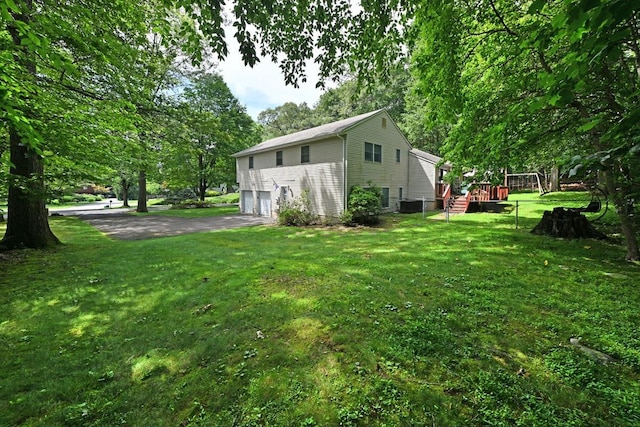 17 E Stemmer Ln, Suffern, NY 10901 - view of property exterior featuring an attached garage, driveway, a lawn, and a deck