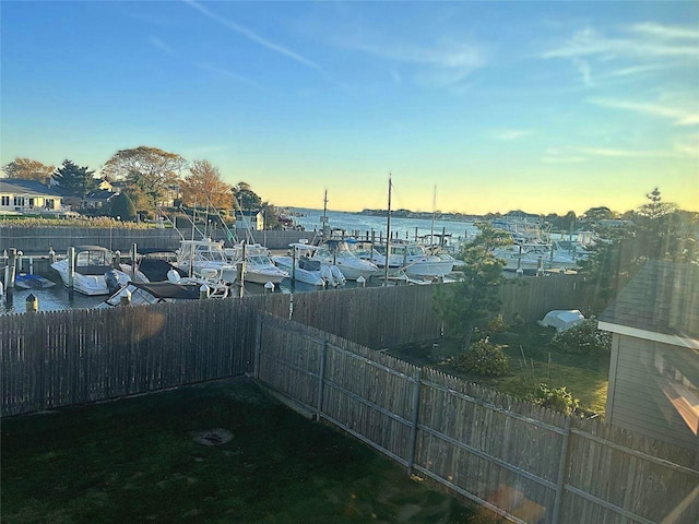 184 Sumpwams Ave, Babylon, NY 11702 - yard at dusk featuring a water view, a fenced backyard, and a boat dock