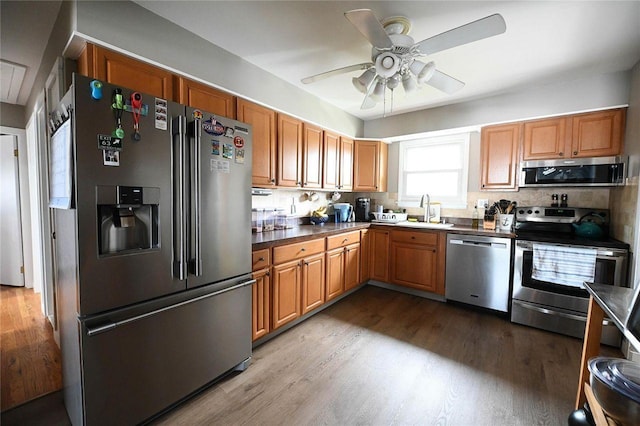 184 Sumpwams Ave, Babylon, NY 11702 - kitchen with appliances with stainless steel finishes, wood finished floors, a ceiling fan, dark countertops, and brown cabinets