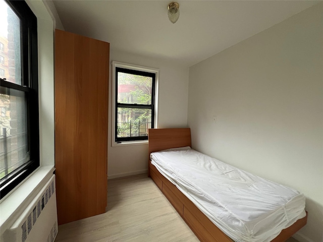 150-15 72nd Rd Unit 1A, Kew Garden Hills, NY 11367 - bedroom with radiator heating unit and light wood-style flooring
