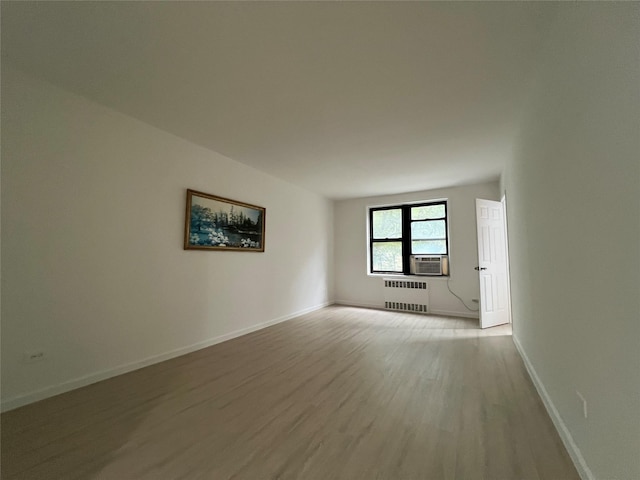 150-15 72nd Rd Unit 1A, Kew Garden Hills, NY 11367 - spare room with radiator heating unit, light wood finished floors, and cooling unit