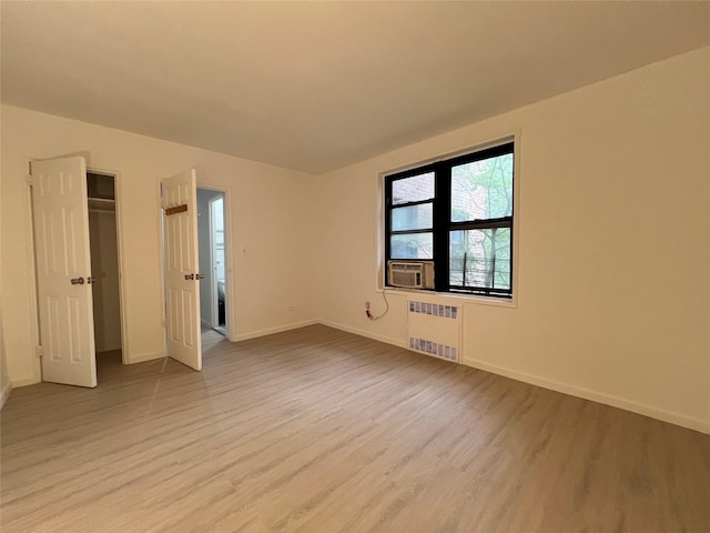 150-15 72nd Rd Unit 1A, Kew Garden Hills, NY 11367 - empty room with radiator heating unit and light wood-style floors