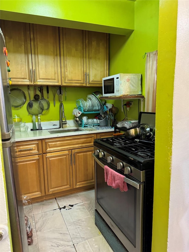 87-70 173rd St Unit 7H, Jamaica, NY 11432 - kitchen with stainless steel appliances, light countertops, light marble finish flooring, and brown cabinets