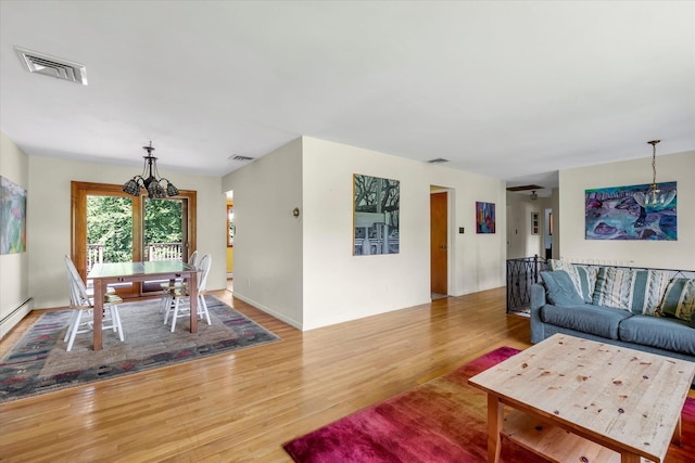 9 Bittersweet Ln, Glen Cove, NY 11542 - living room featuring a chandelier and wood finished floors