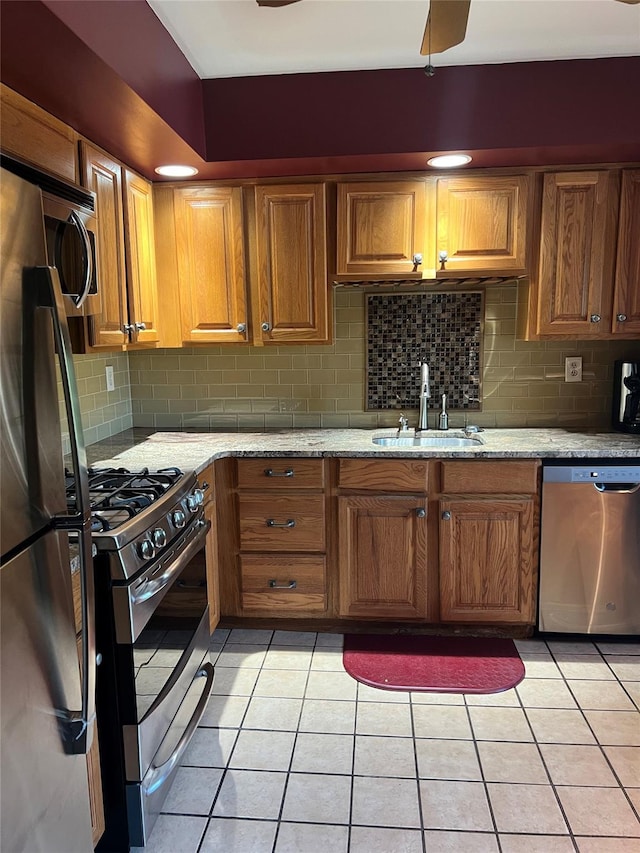 13 Butternut Ct, Highland Mills, NY 10930 - kitchen featuring stainless steel appliances, tasteful backsplash, light tile patterned flooring, brown cabinets, and light stone counters