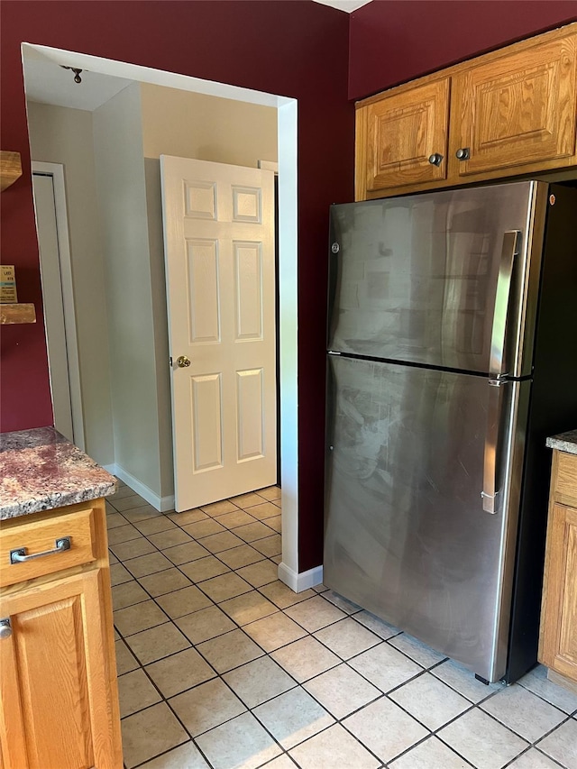 13 Butternut Ct, Highland Mills, NY 10930 - kitchen featuring freestanding refrigerator, light tile patterned floors, light stone counters, and brown cabinets