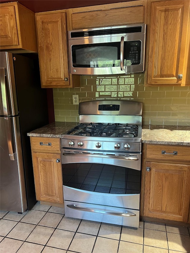 13 Butternut Ct, Highland Mills, NY 10930 - kitchen with stainless steel appliances, light tile patterned floors, decorative backsplash, and brown cabinetry