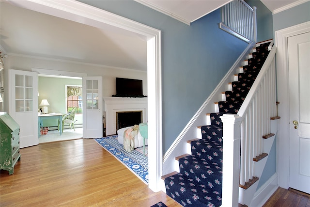 71 Hillcrest Ave, Manhasset, NY 11030 - stairway featuring wood finished floors, crown molding, a fireplace, and baseboard heating