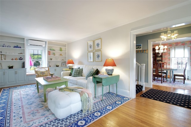 71 Hillcrest Ave, Manhasset, NY 11030 - living room with an AC wall unit, a chandelier, wood finished floors, ornamental molding, and built in features