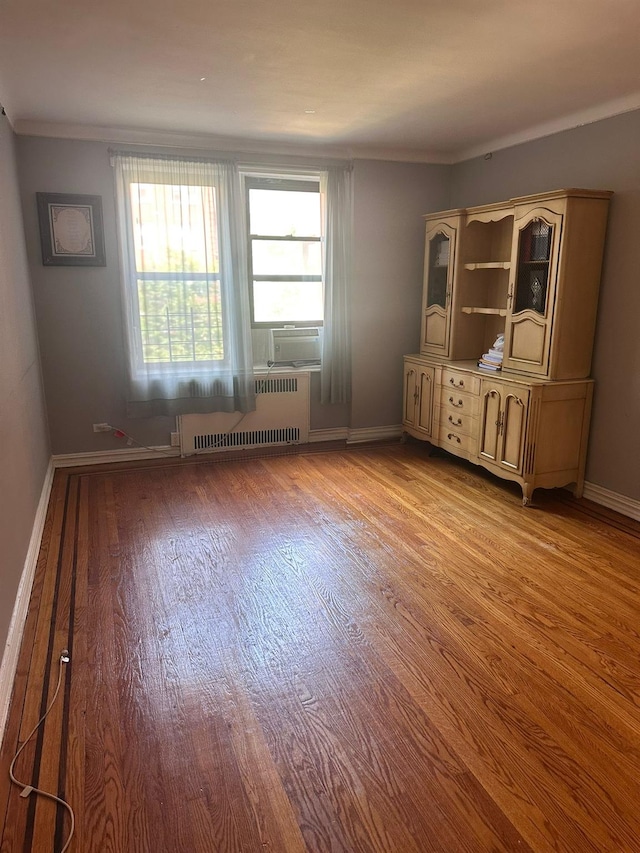 118-14 83rd Ave Unit 2E, Kew Gardens, NY 11415 - unfurnished room with radiator heating unit, wood finished floors, cooling unit, and ornamental molding