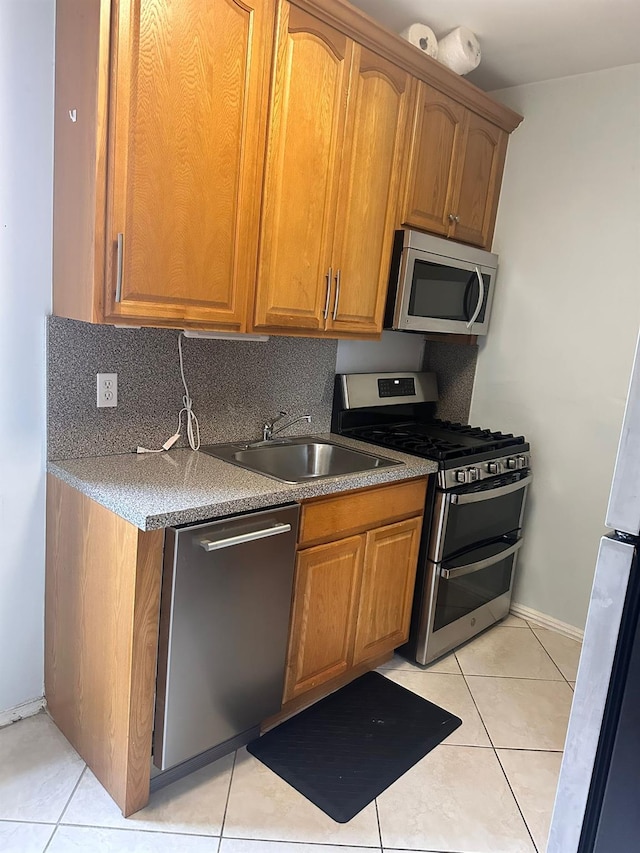 118-14 83rd Ave Unit 2E, Kew Gardens, NY 11415 - kitchen featuring stainless steel appliances, light tile patterned floors, brown cabinets, and tasteful backsplash