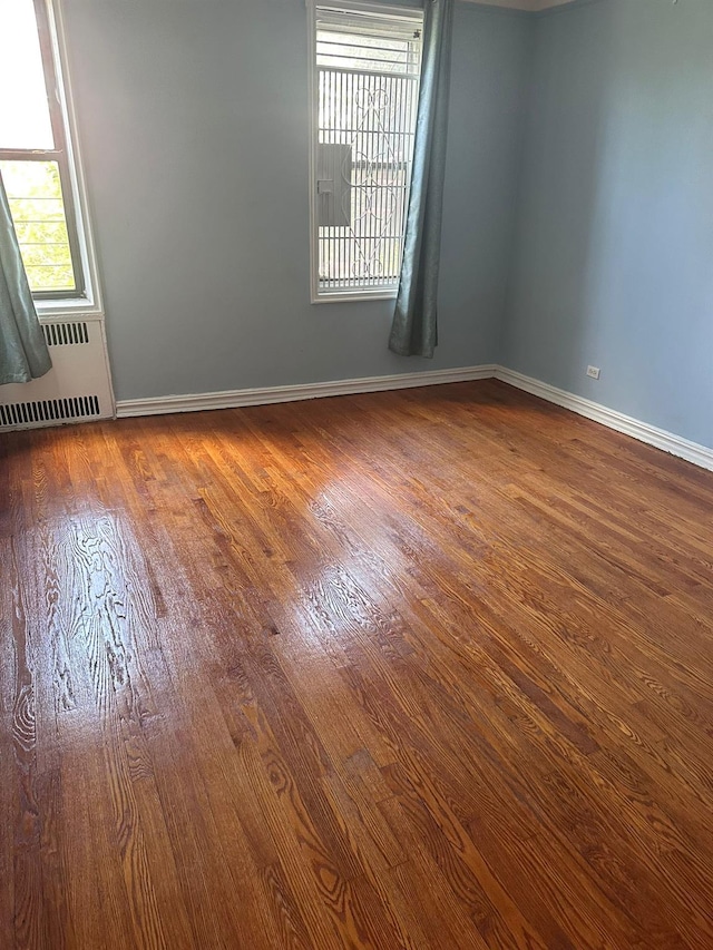 118-14 83rd Ave Unit 2E, Kew Gardens, NY 11415 - empty room with wood finished floors and radiator heating unit
