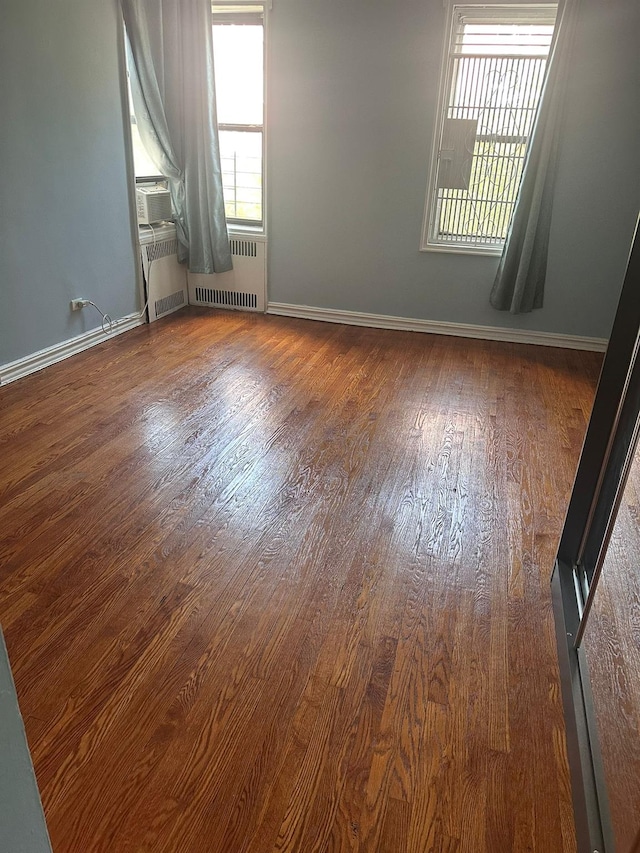 118-14 83rd Ave Unit 2E, Kew Gardens, NY 11415 - unfurnished room featuring radiator, wood finished floors, and cooling unit