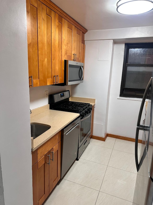 6145 98th St Unit 5J, Rego Park, NY 11374 - kitchen featuring stainless steel appliances, brown cabinets, and light tile patterned flooring