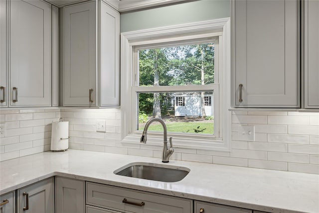 15 Shadetree Ln, Stony Brook, NY 11790 - kitchen with gray cabinetry, decorative backsplash, and light stone counters