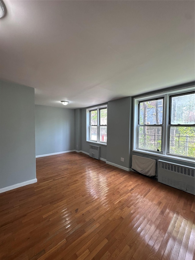 86-16 60th Ave Unit 1C, Elmhurst, NY 11373 - spare room featuring radiator heating unit and hardwood / wood-style flooring