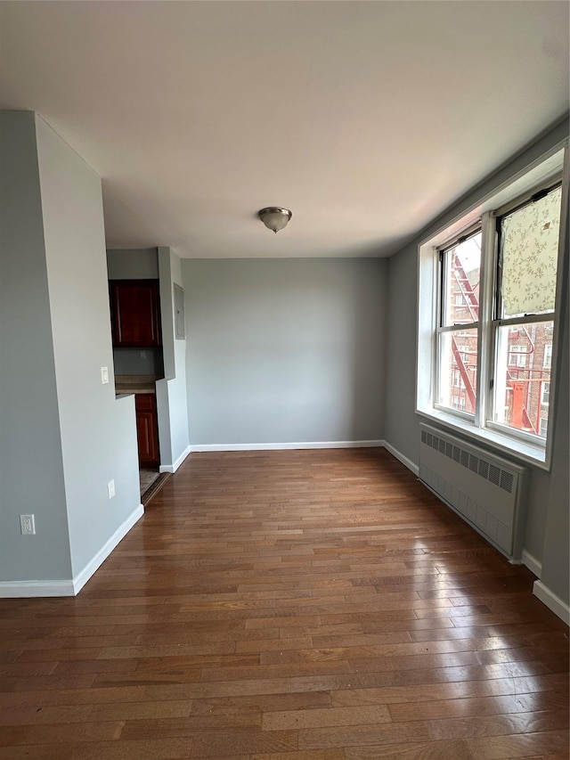 86-16 60th Ave Unit 1C, Elmhurst, NY 11373 - empty room featuring radiator heating unit and dark wood-type flooring