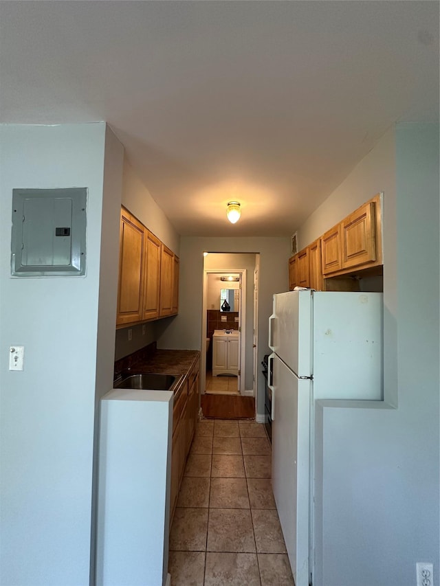 86-16 60th Ave Unit 1C, Elmhurst, NY 11373 - kitchen with electric panel, washing machine and clothes dryer, freestanding refrigerator, dark countertops, and light tile patterned floors
