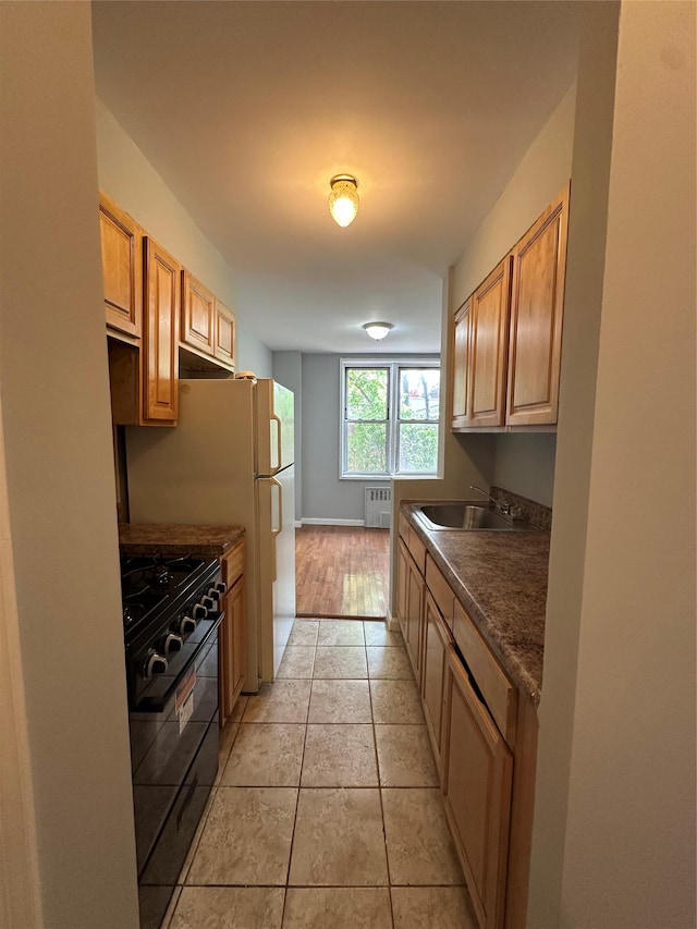 86-16 60th Ave Unit 1C, Elmhurst, NY 11373 - kitchen featuring gas stove, dark countertops, radiator heating unit, and light tile patterned floors